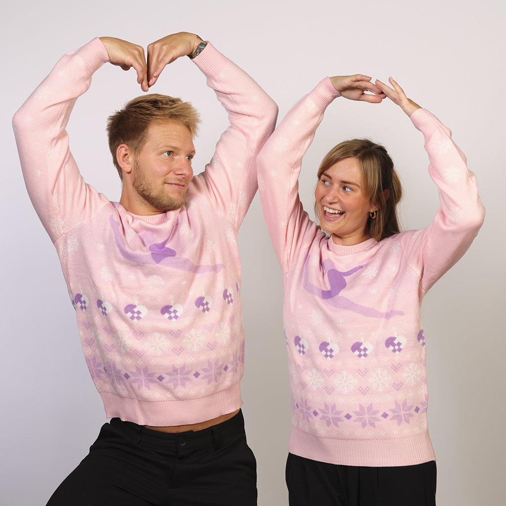 Ett par som poserar som ballerinor i en rosa jultröja med en ballerina på.